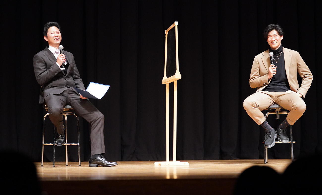 地元中学生を対象に講演会を行い進行役の野中教諭と言葉を交わす湯浅（右）（撮影・森本幸一）