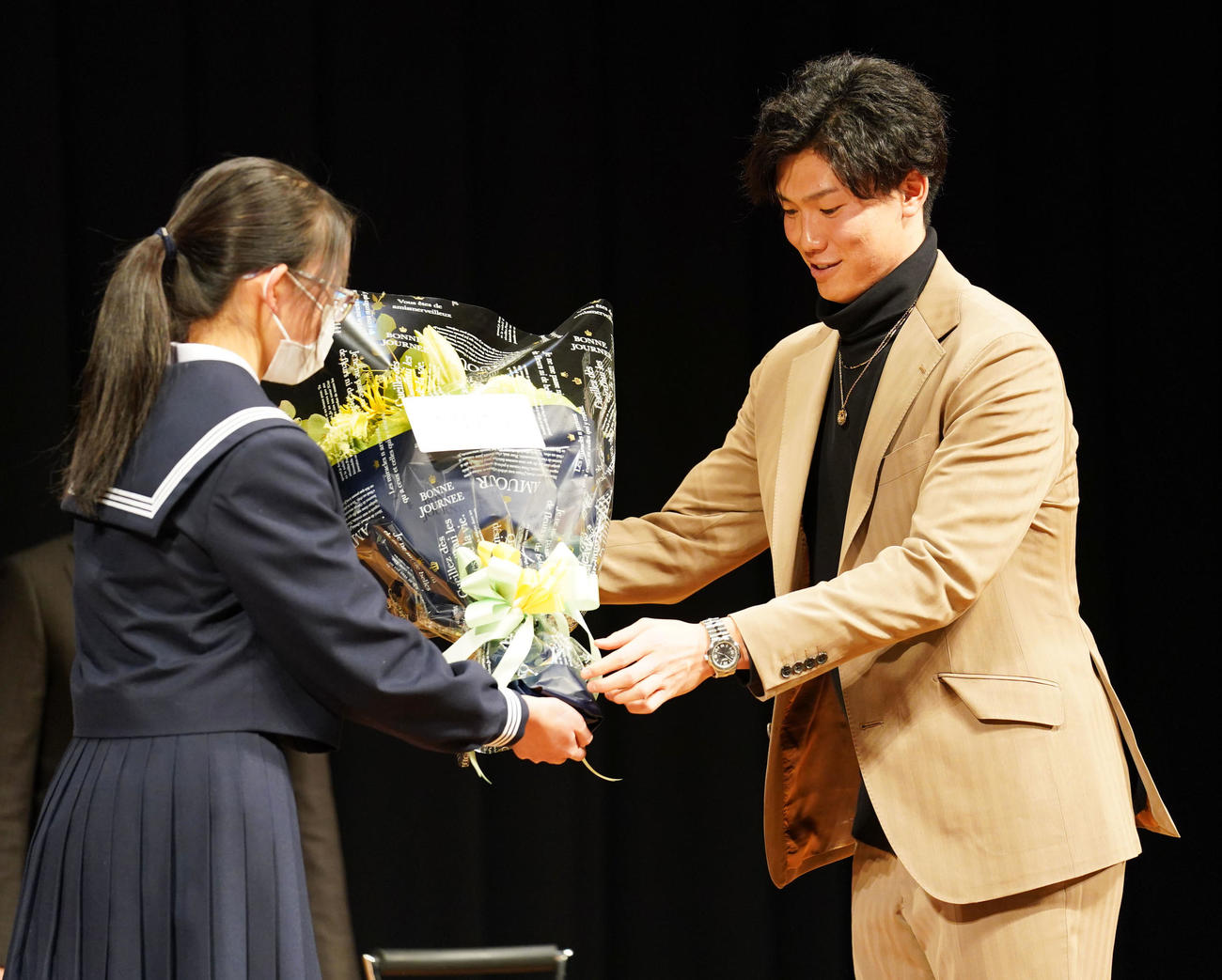 地元中学生らを対象に講演会を行い代表者から花束を受け取る湯浅（撮影・森本幸一）