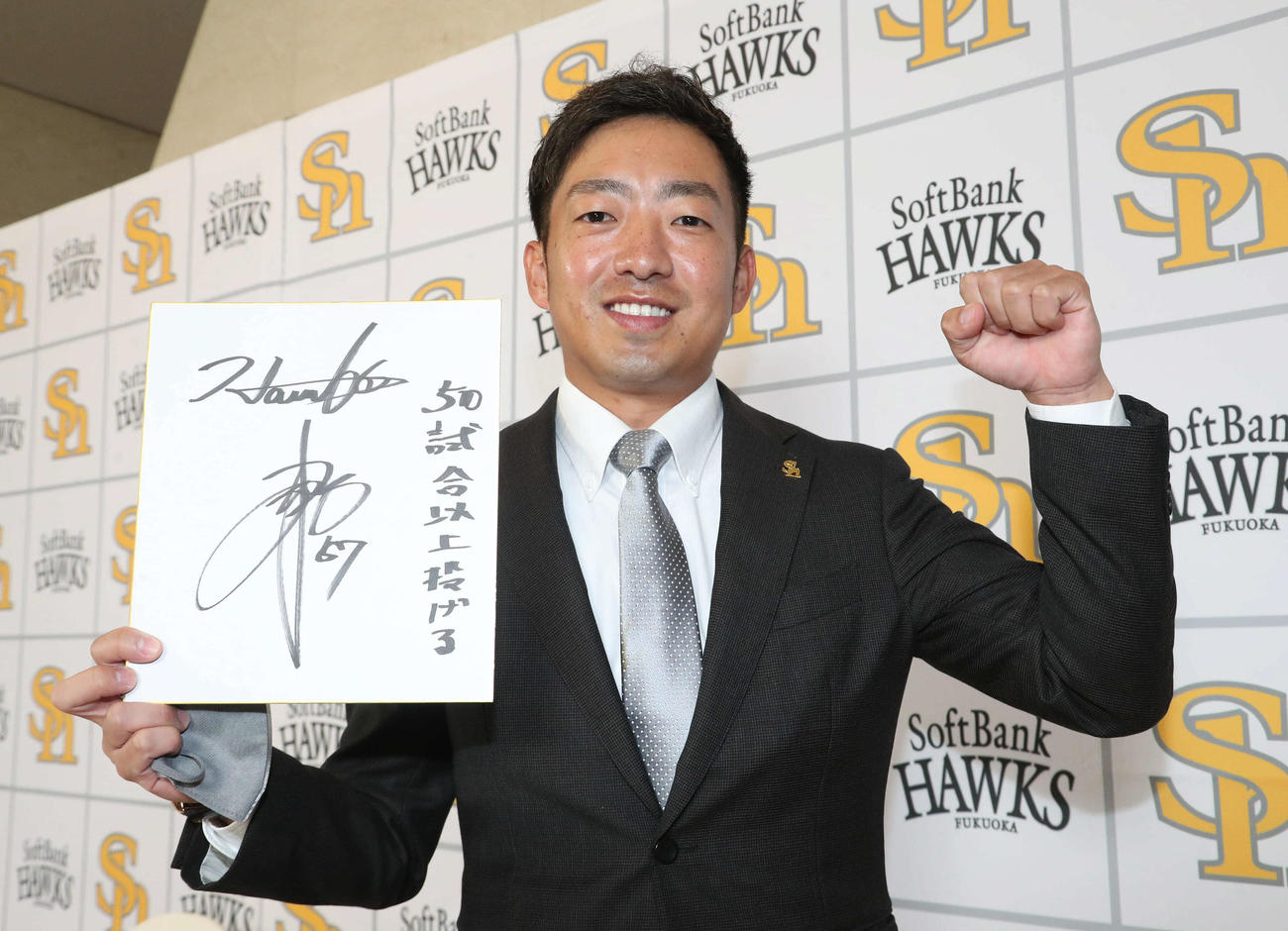 契約更改を終えた嘉弥真は来季の目標を色紙に記しガッツポーズ（撮影・梅根麻紀）