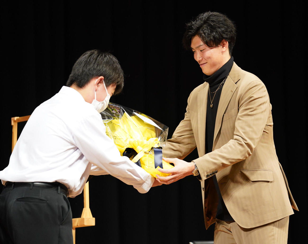 地元中学生らを対象に講演会を行い代表者から花束を受け取る湯浅（撮影・森本幸一）