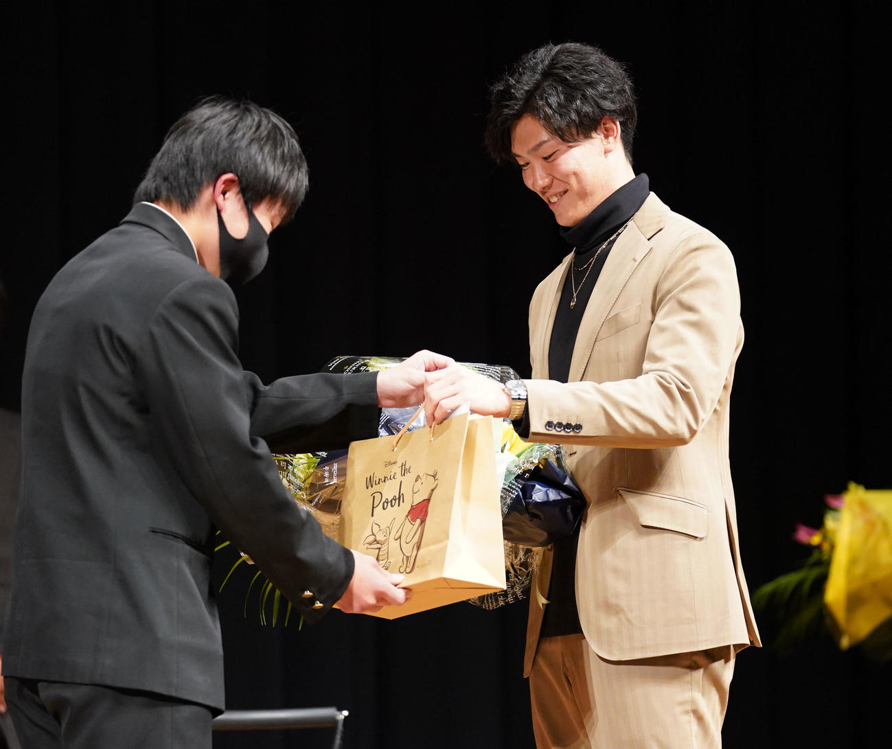 地元中学生らを対象に講演会を行い代表者から記念品を受け取る湯浅（撮影・森本幸一）