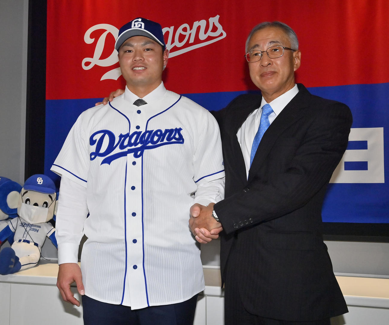 現役ドラフトで中日に移籍し、吉川球団社長（右）と握手を交わす細川（撮影・和賀正仁）