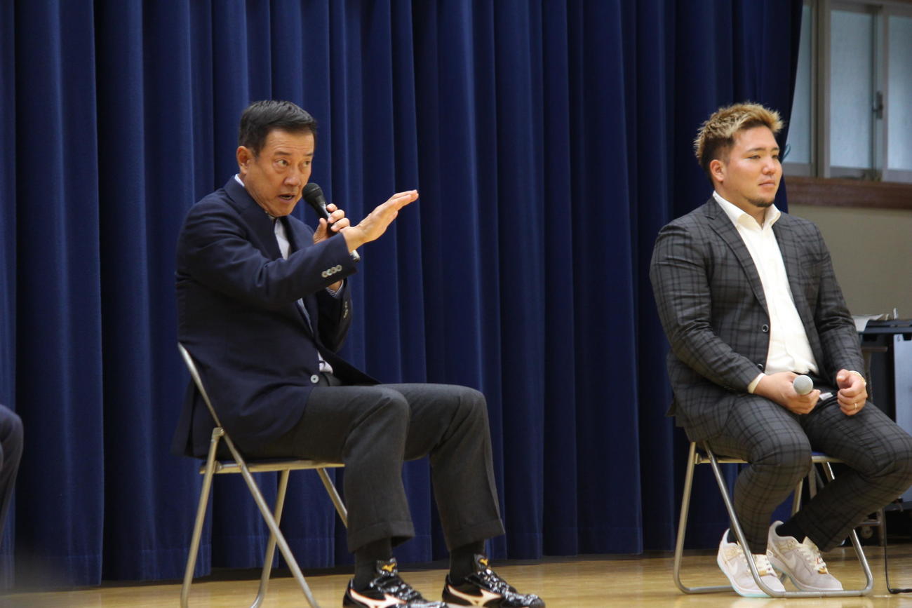 那覇市立城北中学校の児童の前で熱弁を振るう巨人原監督（左）。右は西武山川（撮影・為田聡史）だ