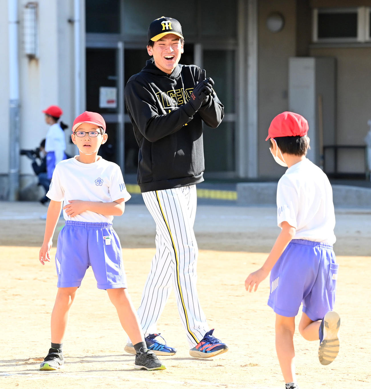 ゲストティーチャーとして西宮市立今津小学校を訪れ児童と笑顔でふれあう高寺（撮影・前岡正明）