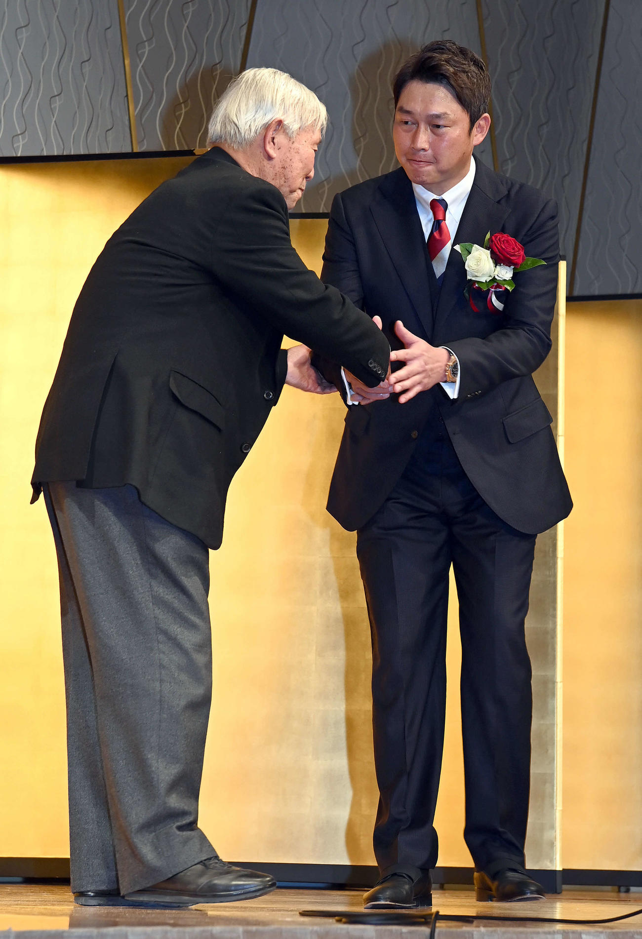 駒大・太田終身名誉監督（左）から激励され、握手を交わす広島新井監督（撮影・たえ見朱実）
