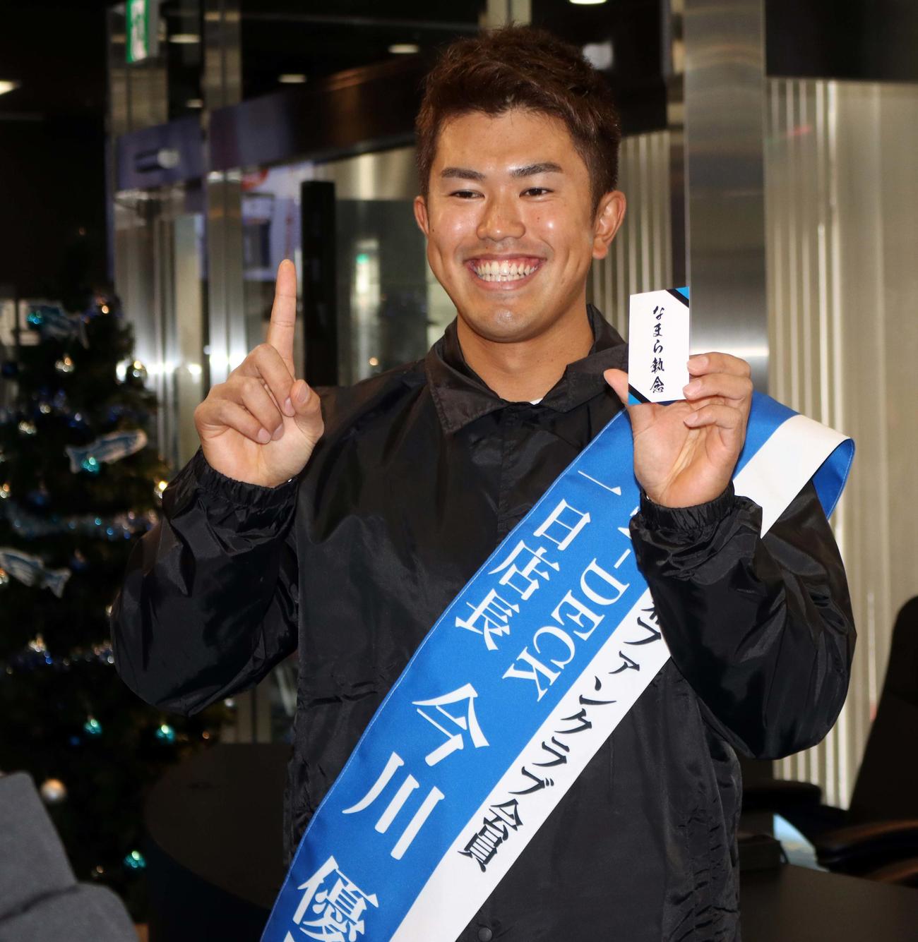 裏に「なまら執念」と記された名刺をかかげ執念ポーズをする日本ハム今川（撮影・永野高輔）