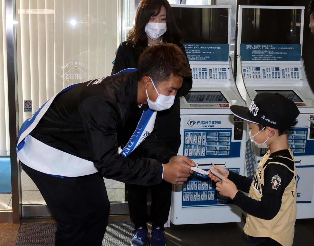 来場者に名刺を渡す日本ハム今川（左）（撮影・永野高輔）
