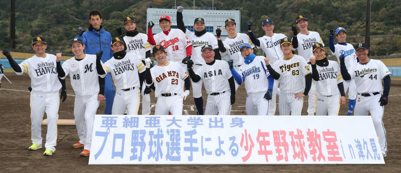 記念撮影で熱男ポーズをする亜大出身プロ選手の野球教室に参加した選手たち。前列右端が頓宮（撮影・屋方直哉）