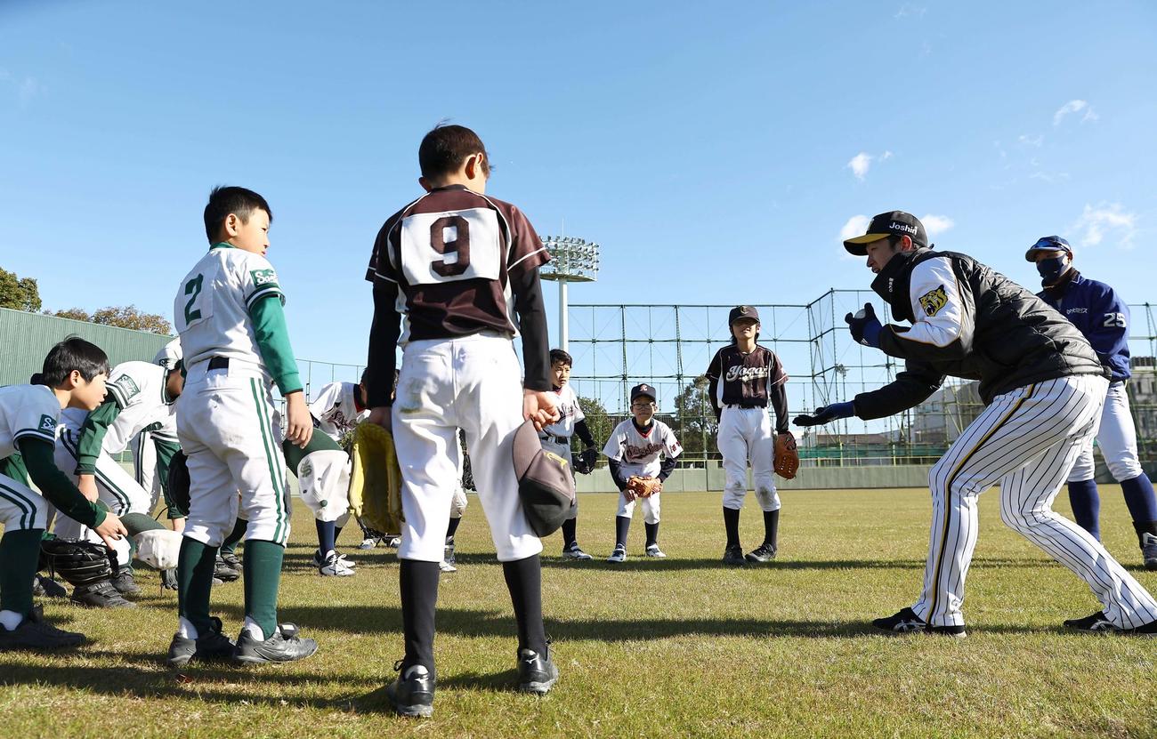 小学生に守備の指導をする近本（撮影・上田博志）