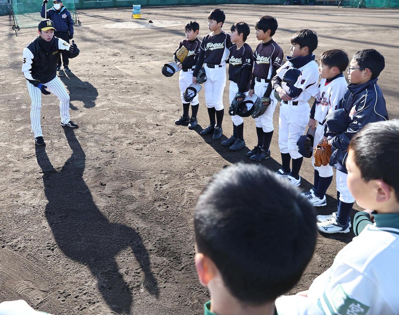 小学生に守備の指導をする近本（撮影・上田博志）