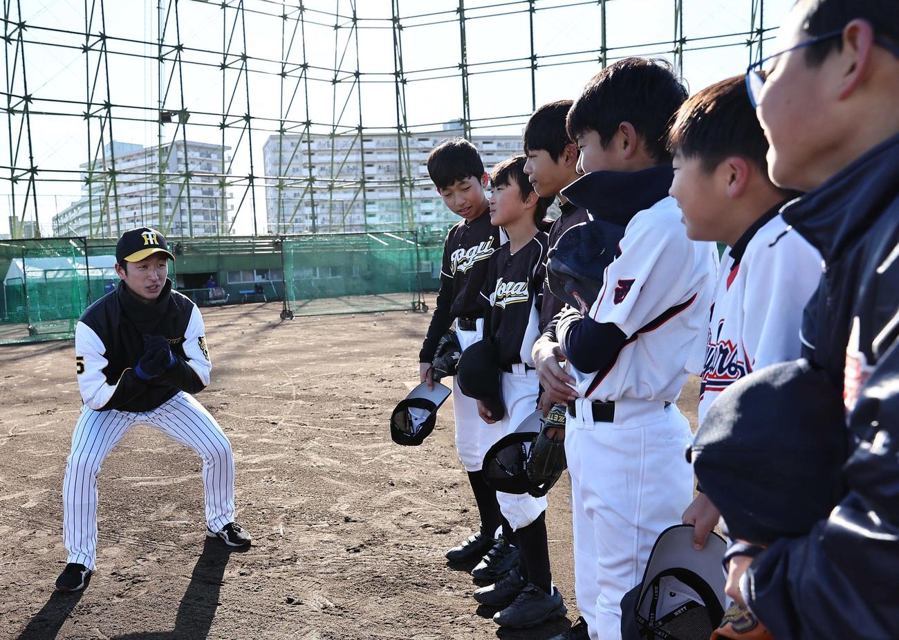 小学生に守備の指導をする近本（撮影・上田博志）