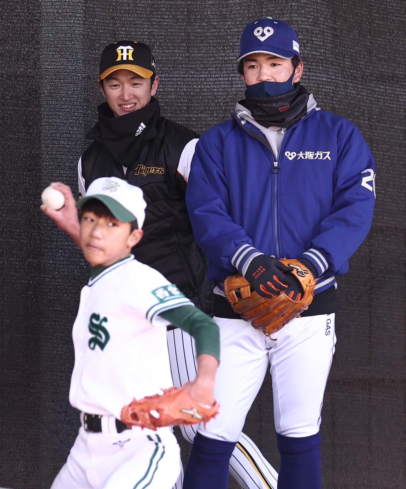小学生の投球をチェックする近本（左）と広島ドラ5河野（撮影・上田博志）