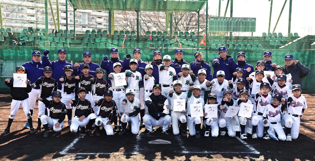 近本（中央下）は指導した小学生球児、大阪ガスナインと記念撮影をする（撮影・上田博志）