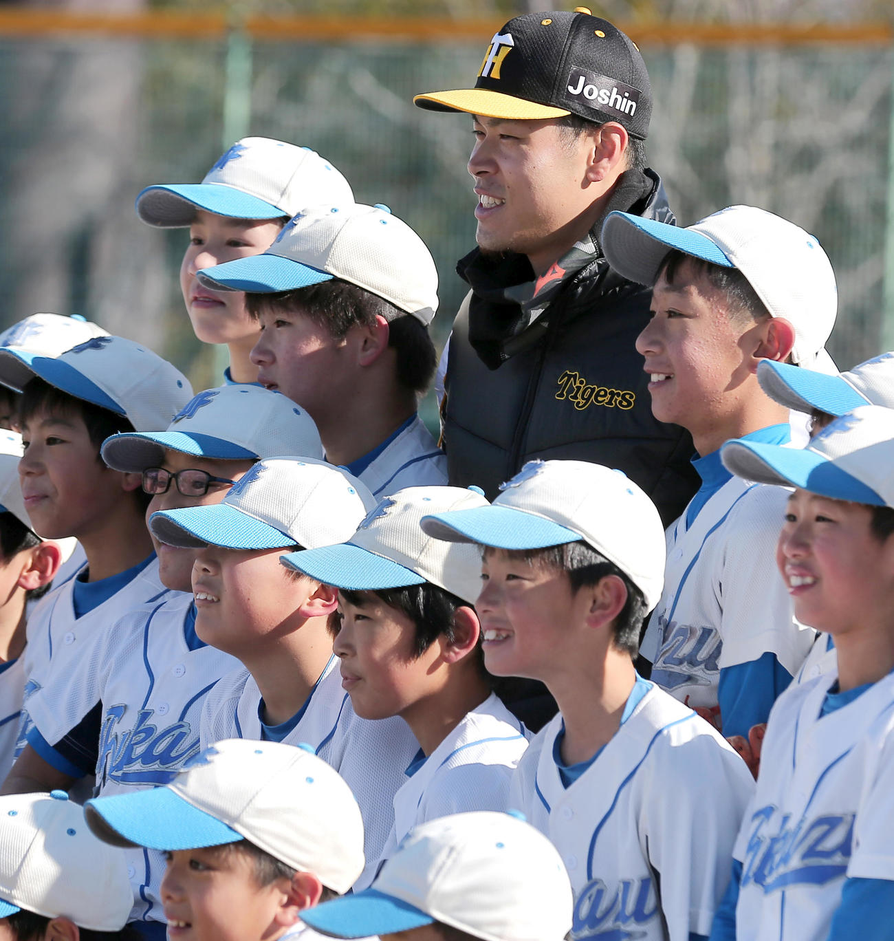 野球教室で子どもたちと記念撮影に納まる佐藤輝（撮影・上山淳一）