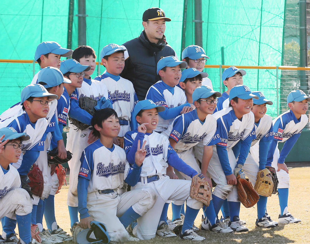 野球教室で子どもたちと記念撮影に納まる佐藤輝（撮影・上山淳一）
