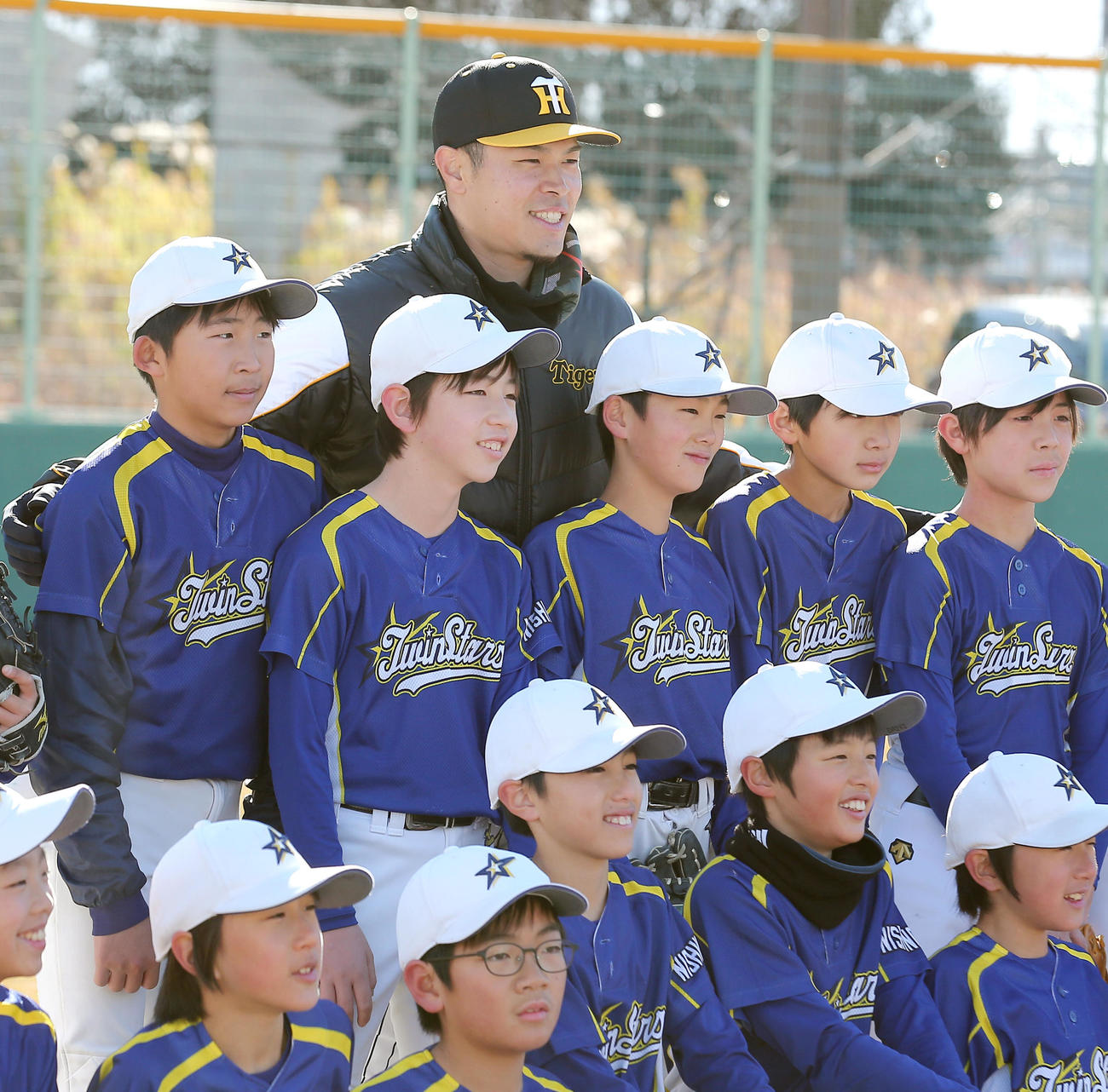 野球教室で子どもたちと記念撮影に納まる佐藤輝（撮影・上山淳一）
