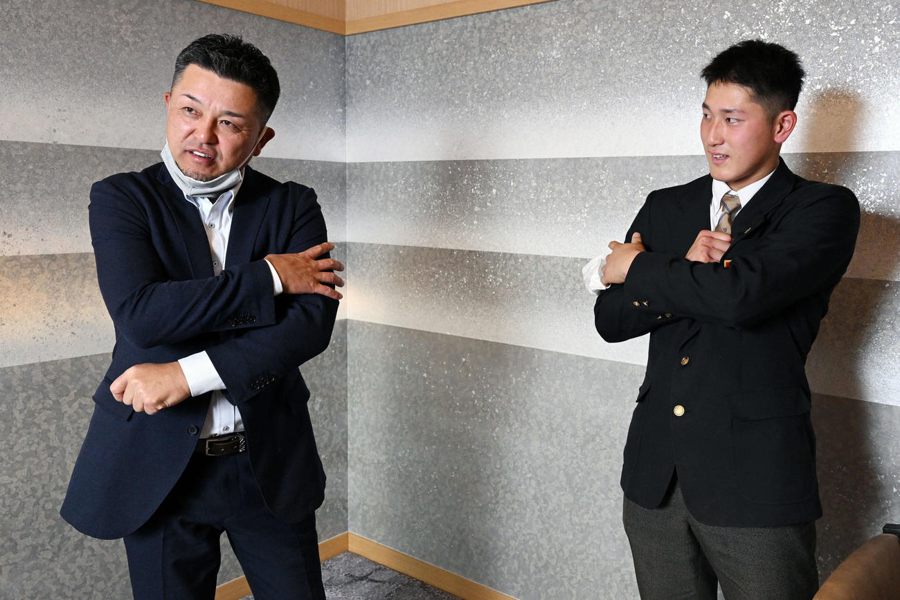 DeNAドラフト1位の大阪桐蔭・松尾（右）と自身の腕の太さを比べる谷繁氏（撮影・滝沢徹郎）