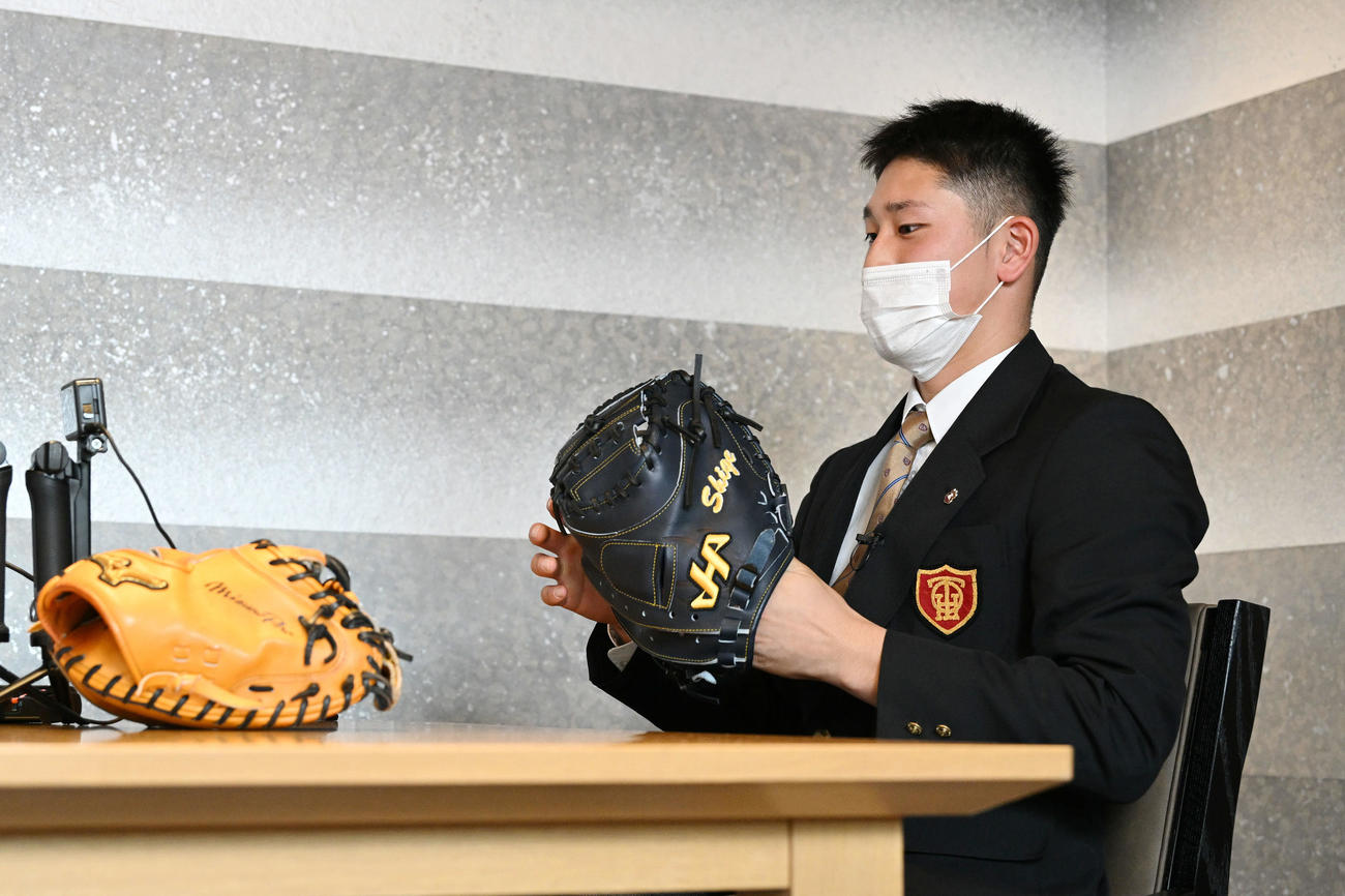 対談する谷繁氏のミットを着けるDeNAドラフト1位の大阪桐蔭・松尾（撮影・滝沢徹郎）