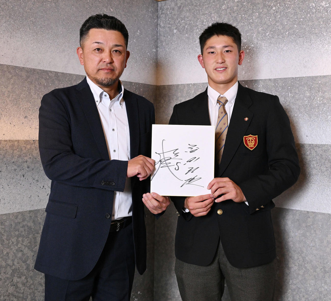色紙にサインをしたためた谷繁氏（左）とDeNAドラフト1位の大阪桐蔭・松尾（撮影・滝沢徹郎）