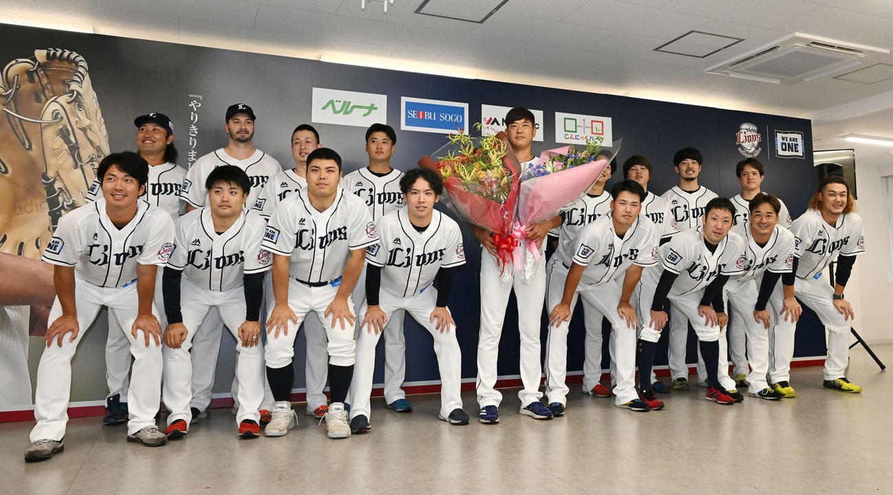 引退会見で投手陣から花束を受け取り記念撮影する西武内海（中央）（2022年9月19日撮影）