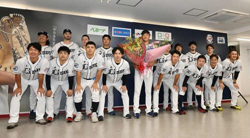 引退会見で投手陣から花束を受け取り記念撮影する西武内海(中央)(2022年9月19日撮影)