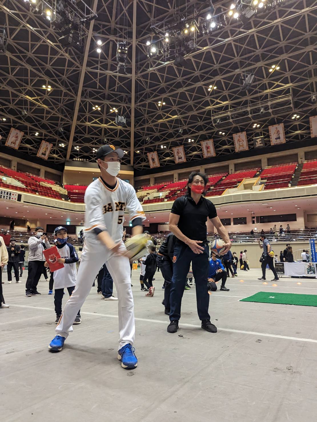ラグビー元日本代表主将の大野均さん（右）から指導を受けラグビーボールを投げる巨人秋広優人内野手（撮影・三須一紀）