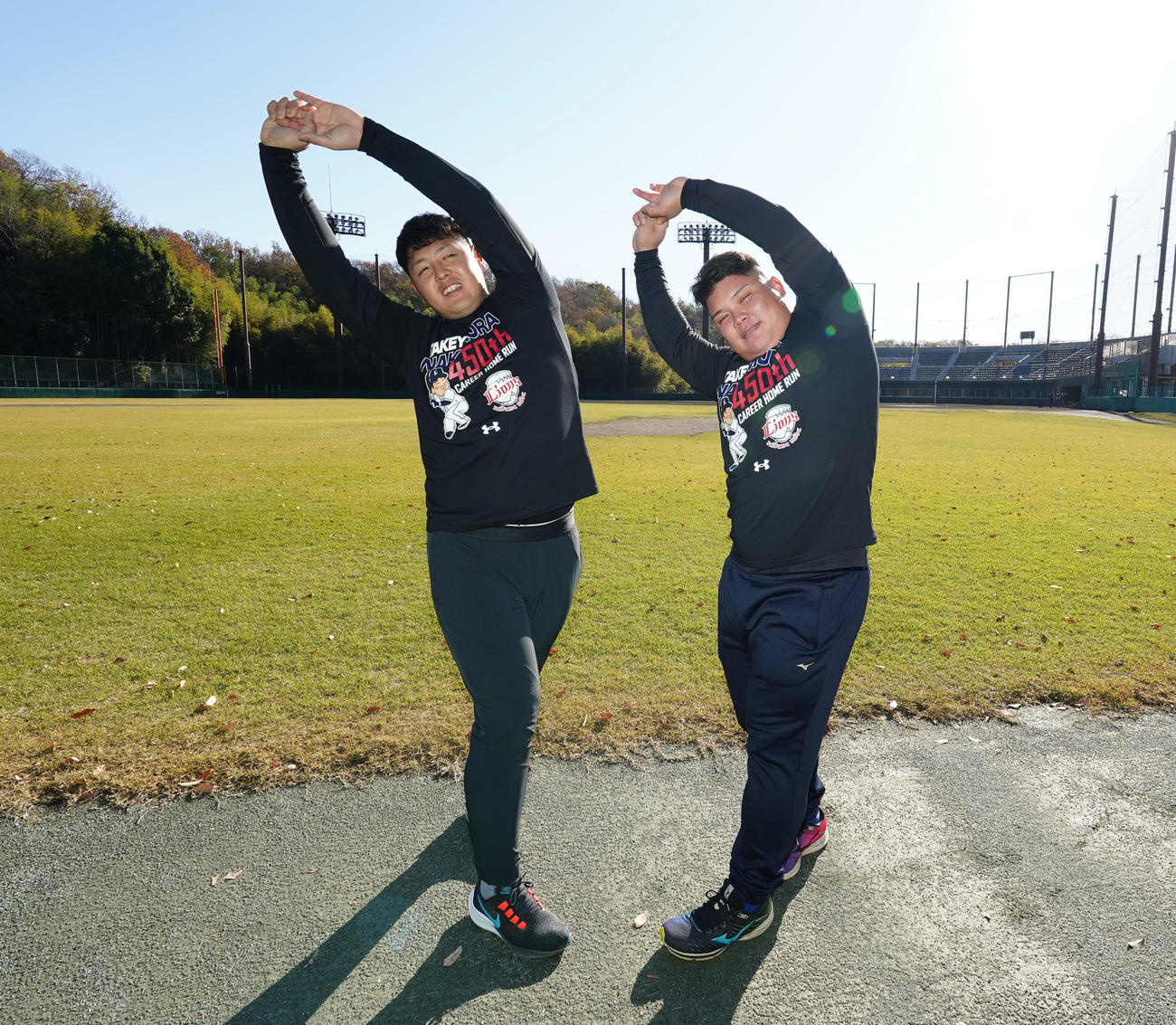 合同自主トレでストレッチをする巨人岡本和（左）と西武渡部（撮影・菅敏）