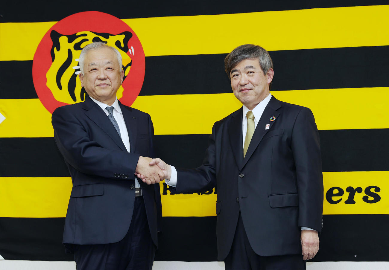 オーナー交代会見を終え握手を交わす阪神杉山新オーナー（右）と藤原前オーナー（撮影・前田充）