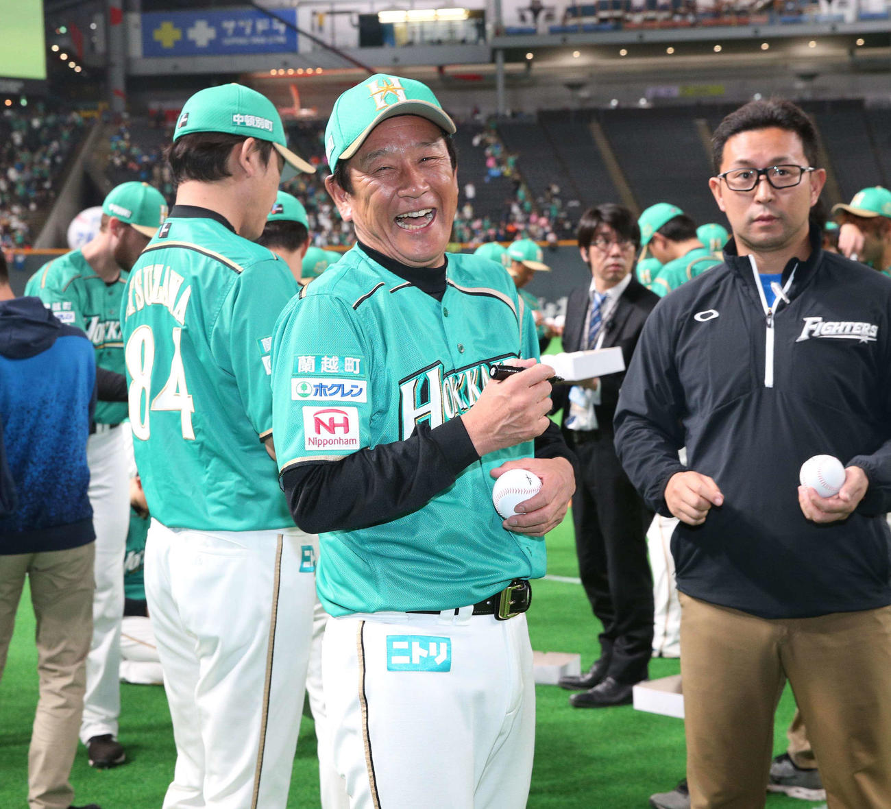 19年5月8日、日本ハム対オリックス　試合後、笑顔でボールにサインする日本ハム栗山監督（中央）