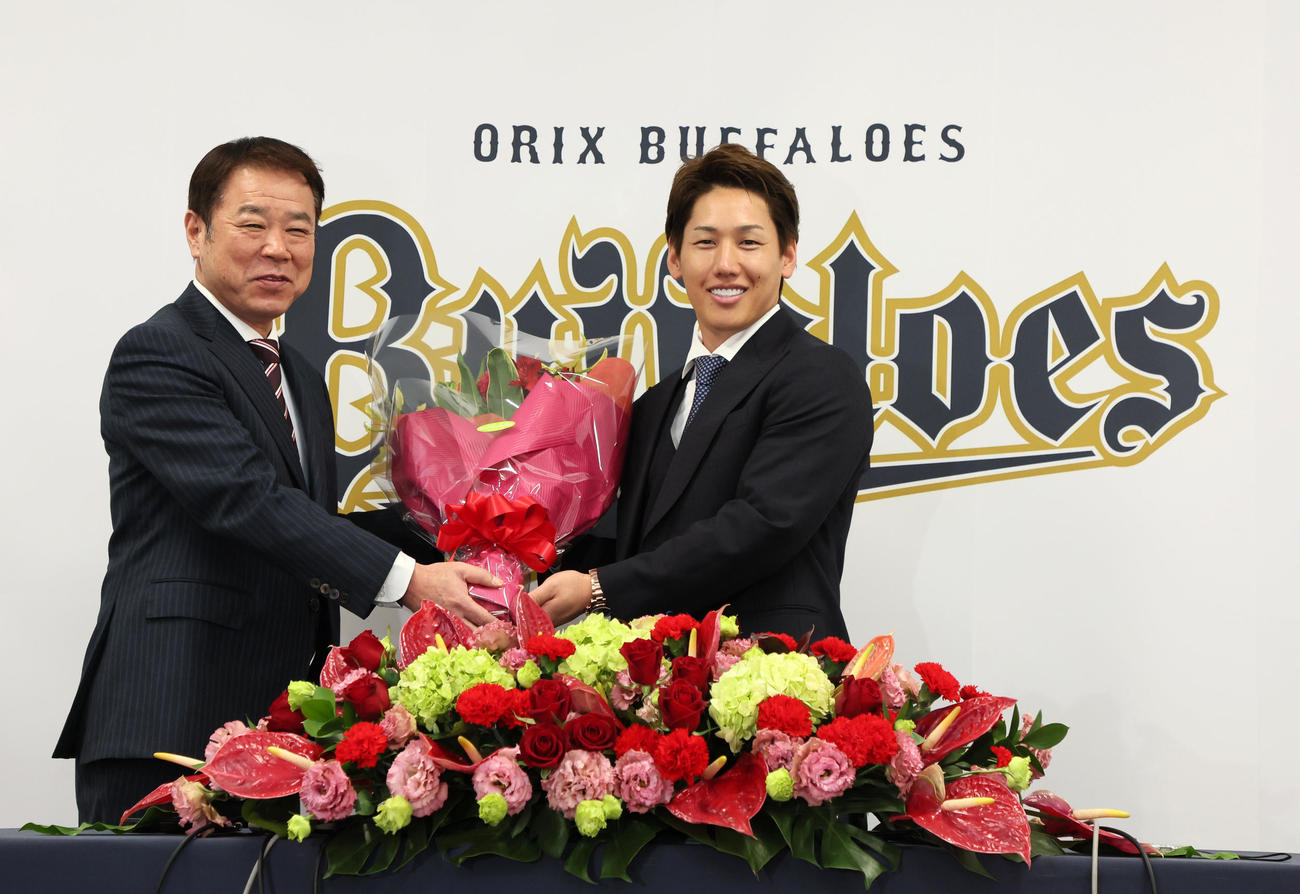 レッドソックスへのポスティング移籍が決まりオリックス福良GM（左）から花束を受け取る吉田正（撮影・加藤哉）