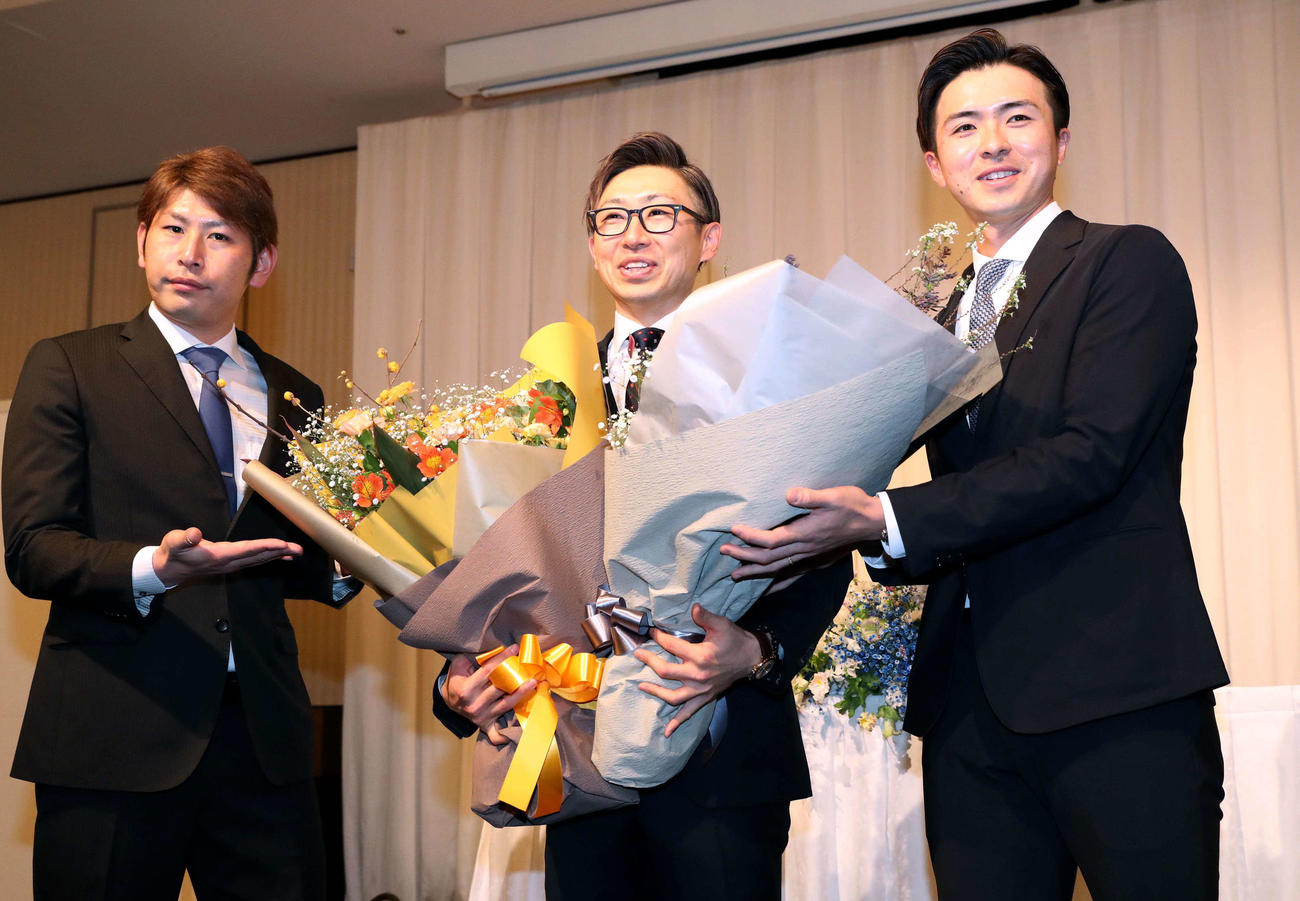 引退会見で加藤（左）と上沢（右）から花束を受け取る日本ハム金子（撮影・黒川智章）