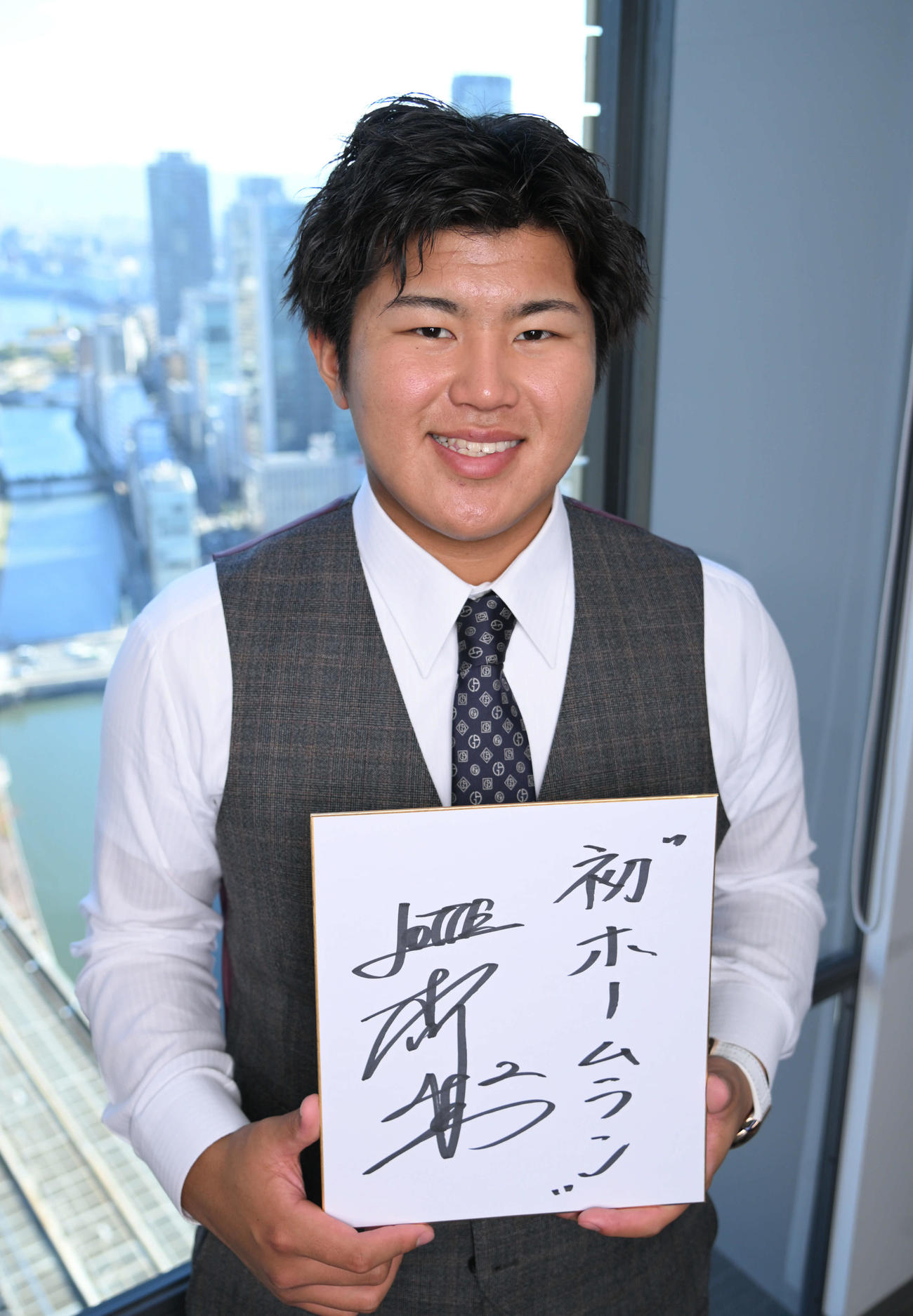 来季の抱負を書いた色紙を持ち笑顔を見せるロッテ松川（撮影・石井愛子）