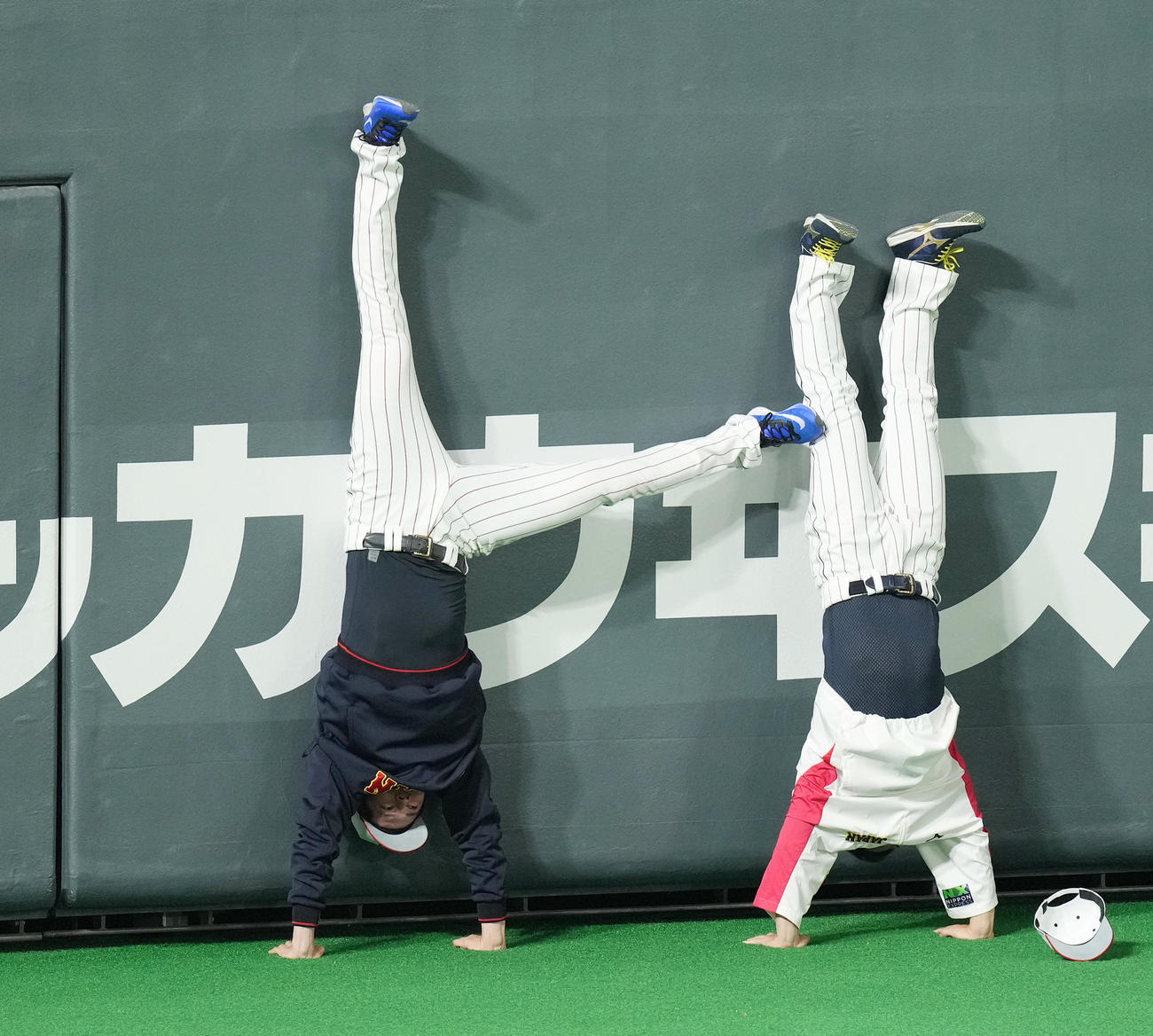 11月9日　日本対オーストラリア　試合前、宮城（右）と逆立ちする佐々木朗は、蹴ってバランスを崩させる