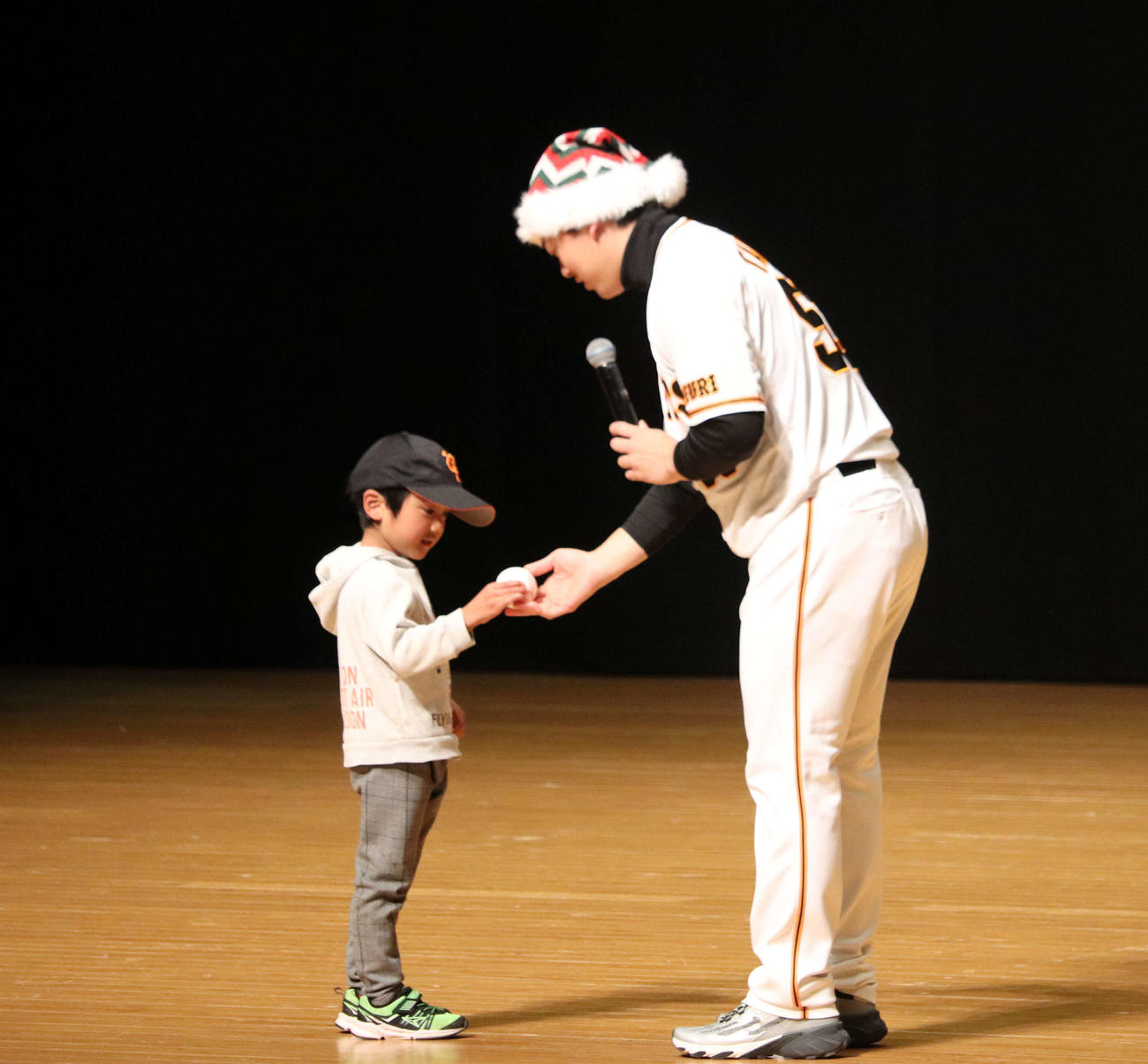 サンタの帽子をかぶって子どもにサインボールをプレゼントした巨人高梨（撮影・小早川宗一郎）