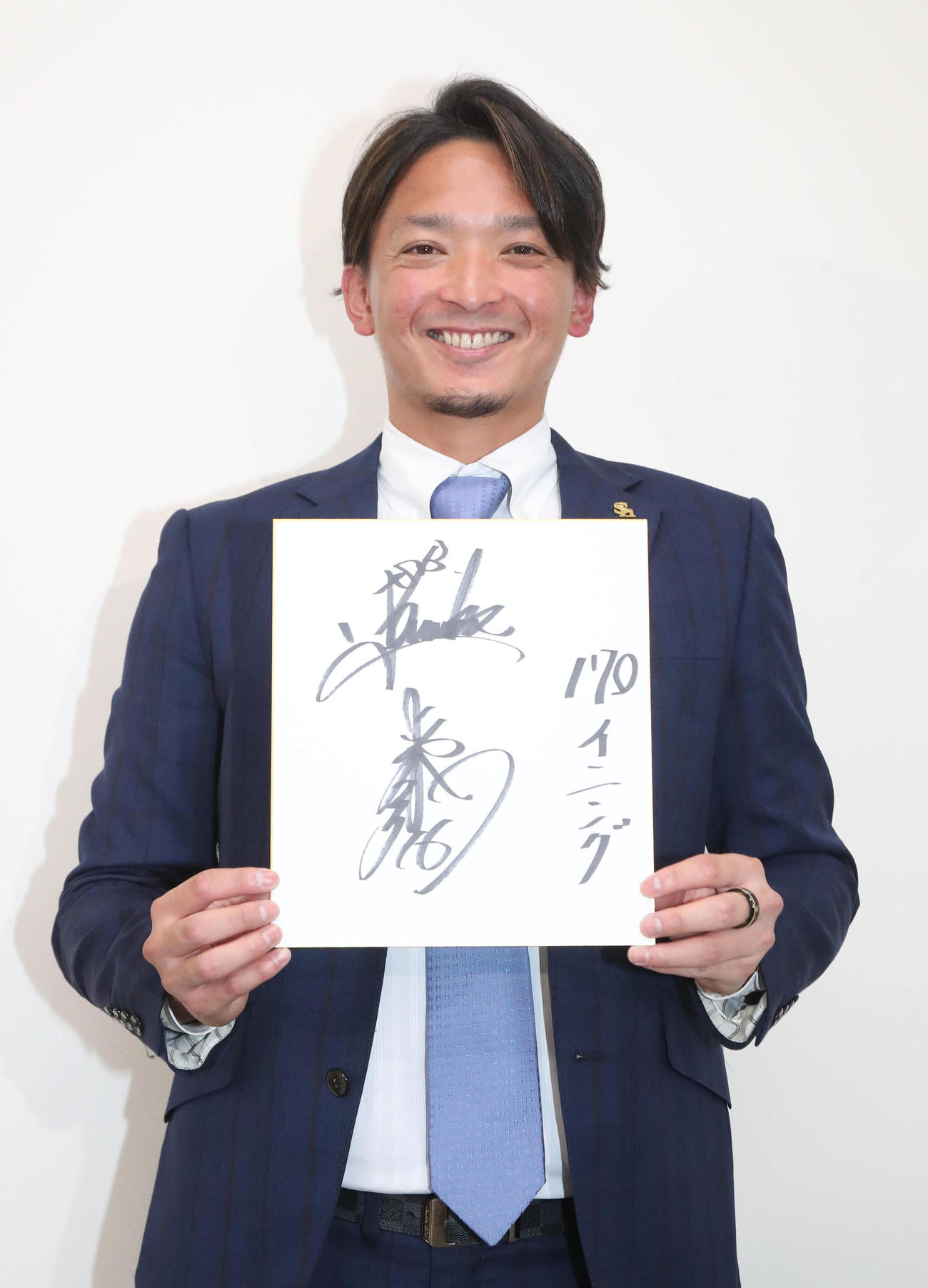 契約更改を終えた東浜巨は色紙に「170イニング」と記し笑顔（撮影・梅根麻紀）
