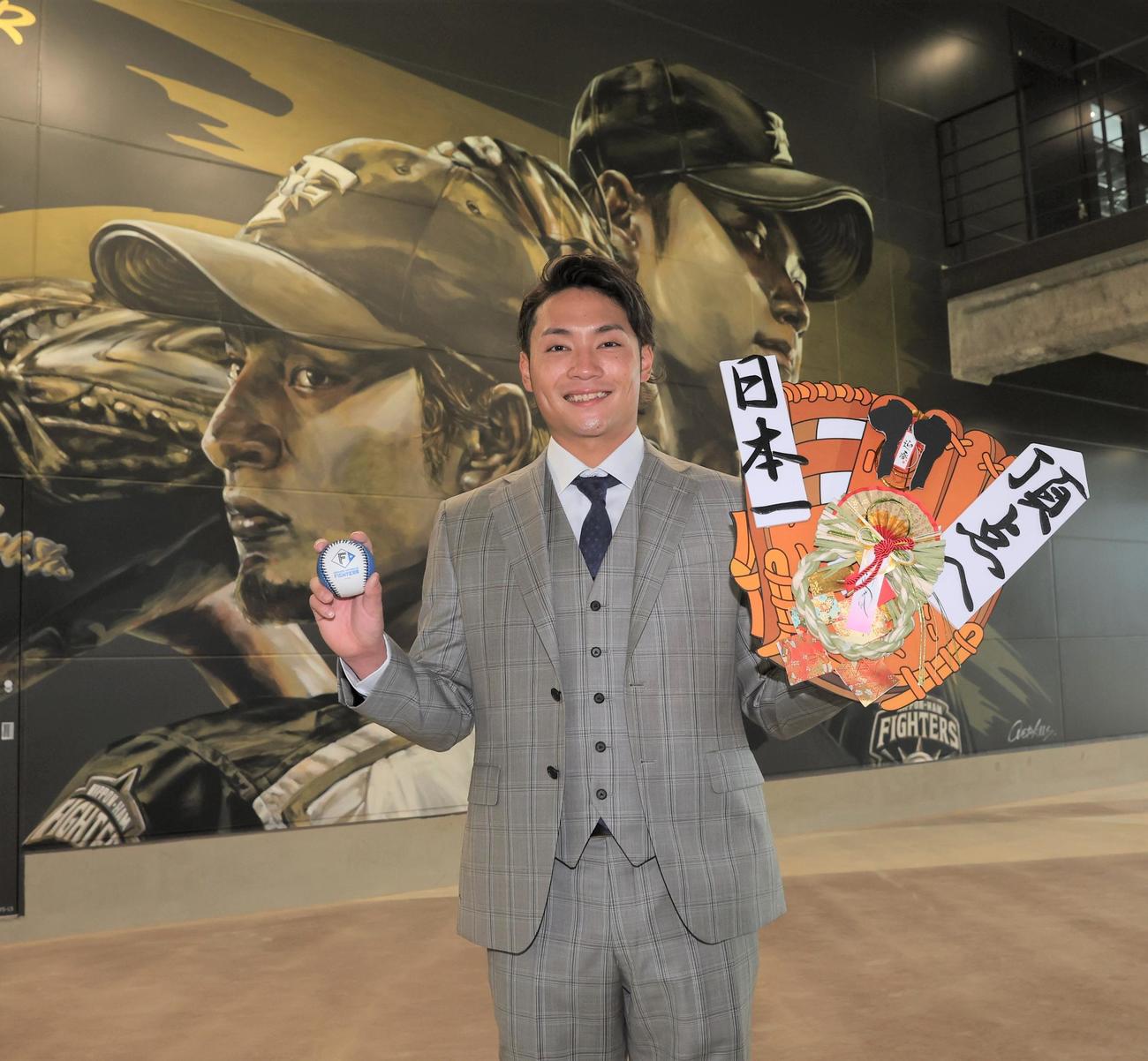 2年連続10勝をマークした日本ハム伊藤は、背番号「11」を付けていたダルビッシュ、大谷にあやかり、壁画の前でキャリアハイの11勝を目指し意気込む（撮影・黒川智章）