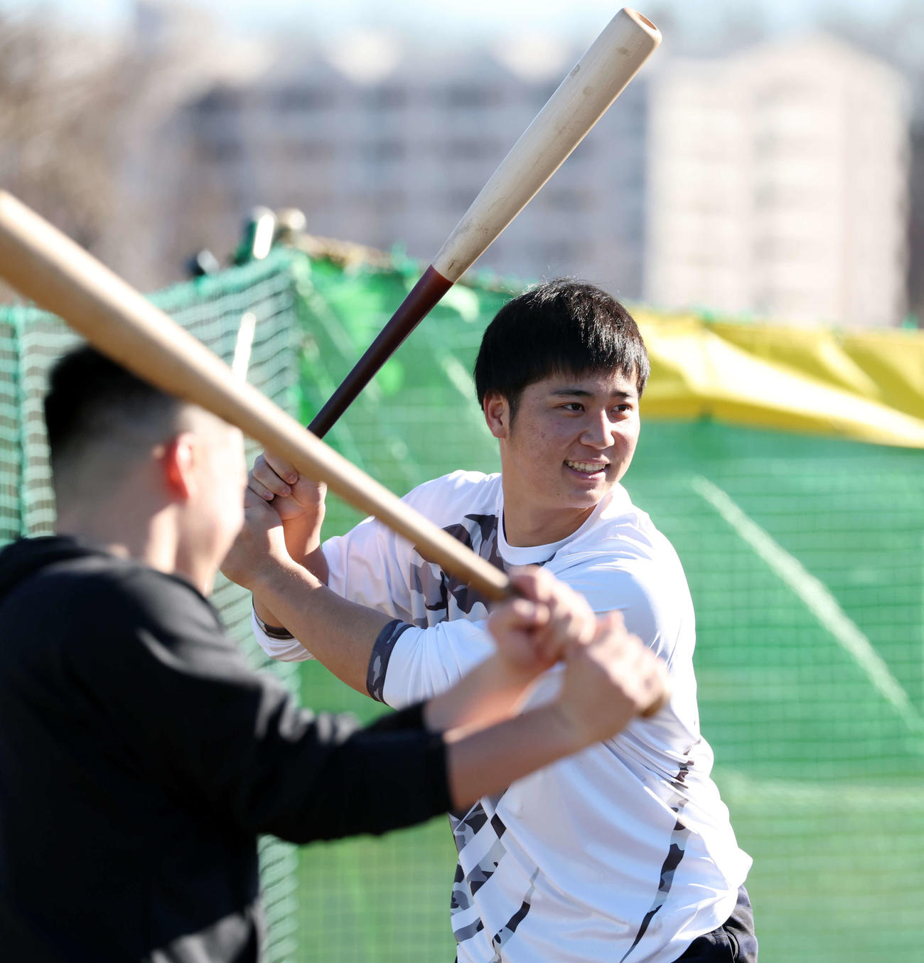 新人自主トレを公開した阪神井坪（右）は八王子リトルシニア時代の同級生と笑顔で素振りする（撮影・浅見桂子）