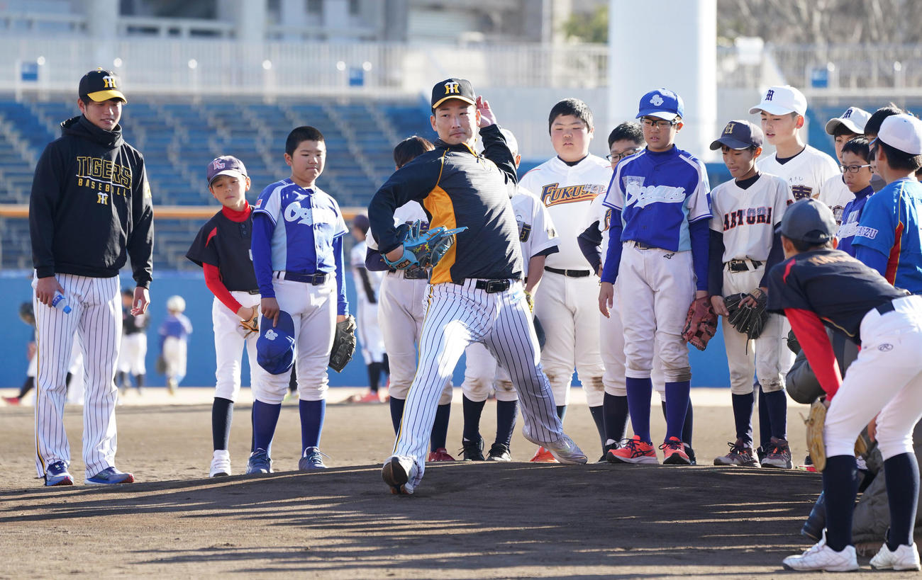 野球教室で子どもたちにマウンドから投球フォームを披露する岩崎（中央）（撮影・森本幸一）