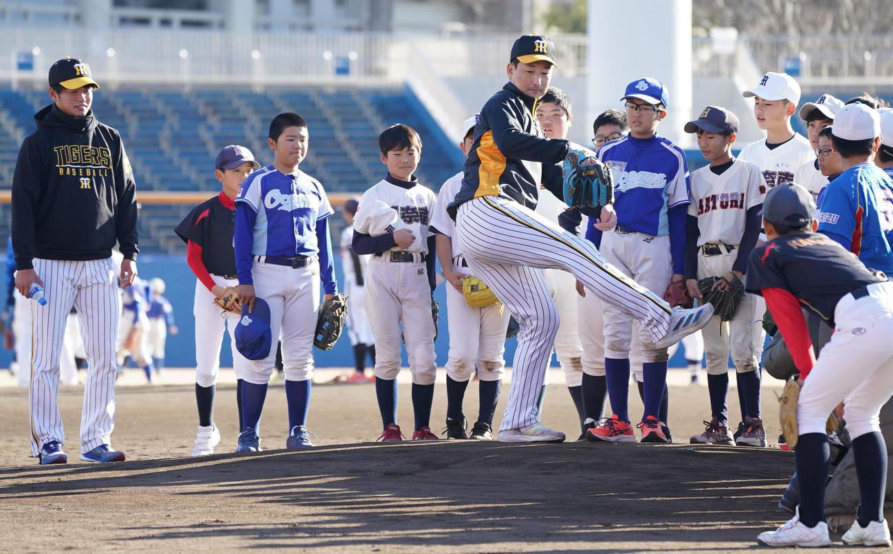 野球教室で子どもたちにマウンドから投球フォームを披露する岩崎（中央）（撮影・森本幸一）