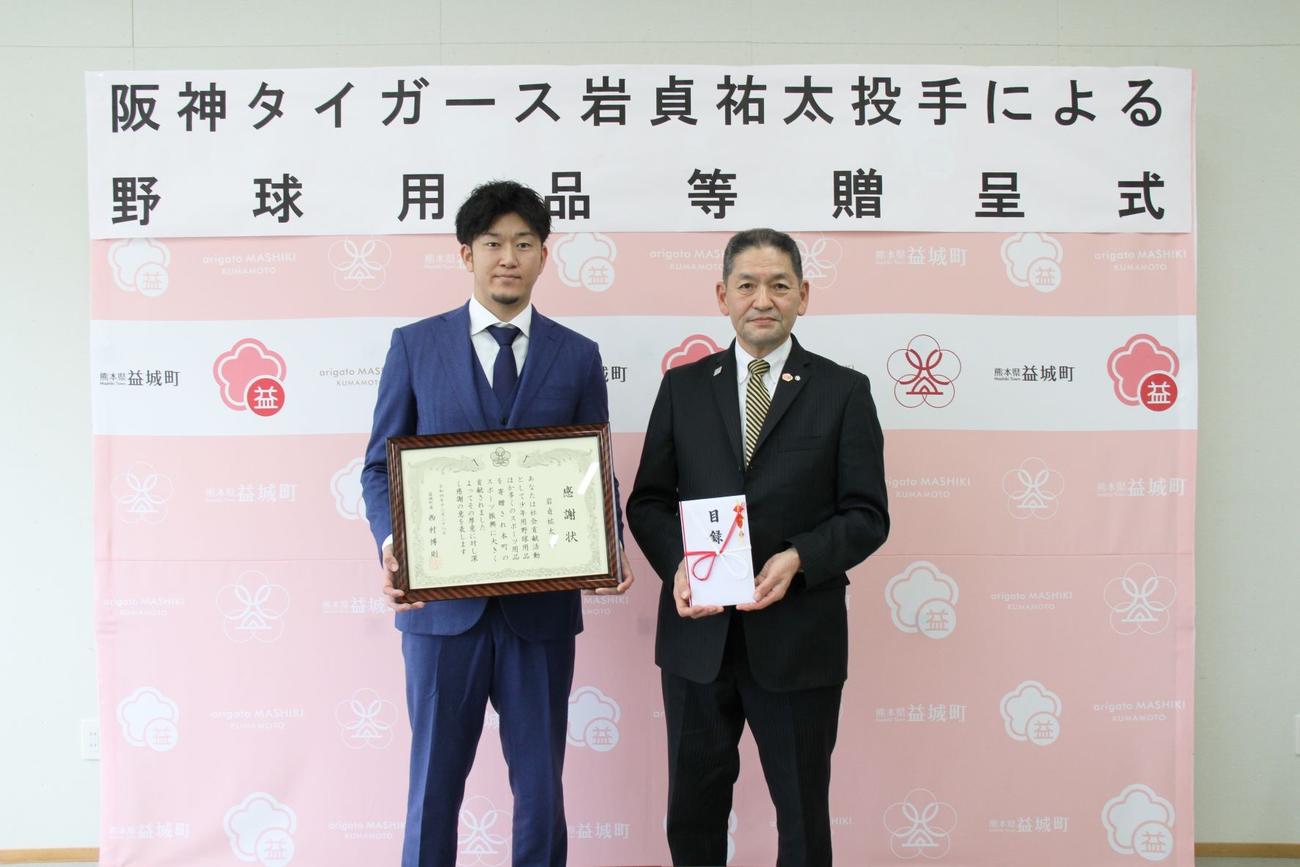 熊本県益城町役場を訪問し、野球用品等の寄贈を行った阪神岩貞。右は西村町長（球団提供）