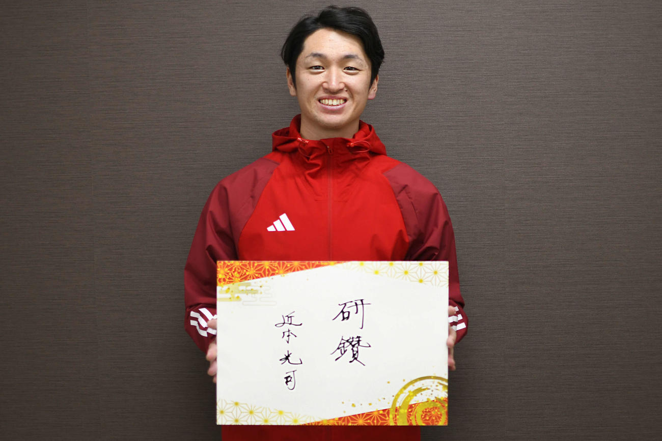 日刊スポーツコラム「研鑽（けんさん）」の題字を手にする阪神近本（撮影・中野椋）