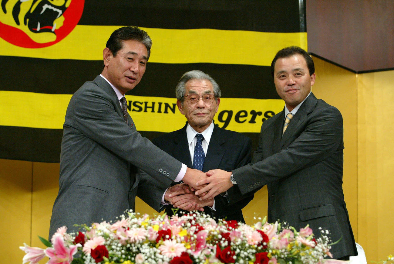 03年10月、新監督就任を発表し、星野前監督（左）、久万阪神球団オーナー（中）と握手を交わす岡田監督