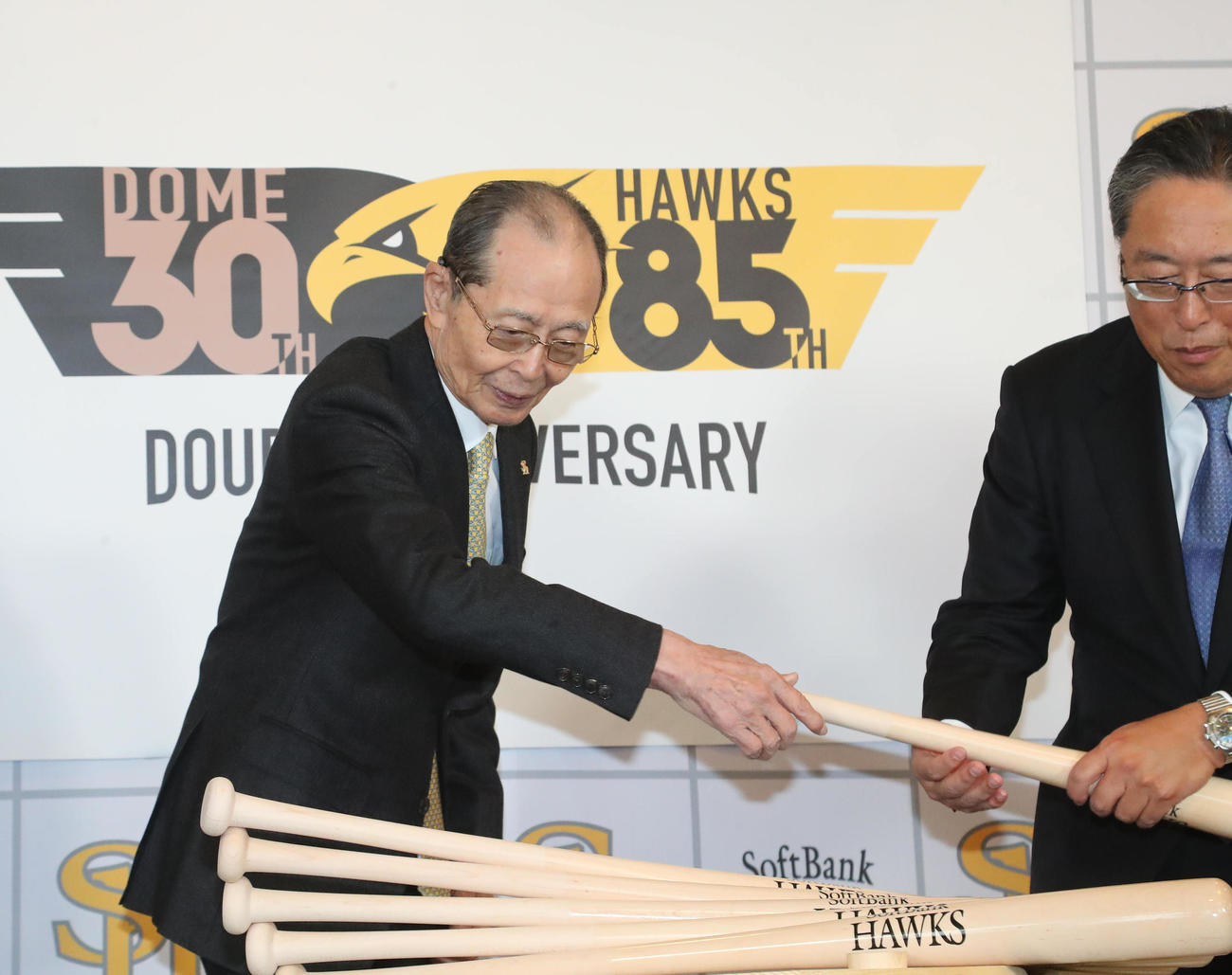 鏡割りの前に、バットを配る気配りを見せる王貞治会長、右は後藤芳光取締役（撮影・梅根麻紀）