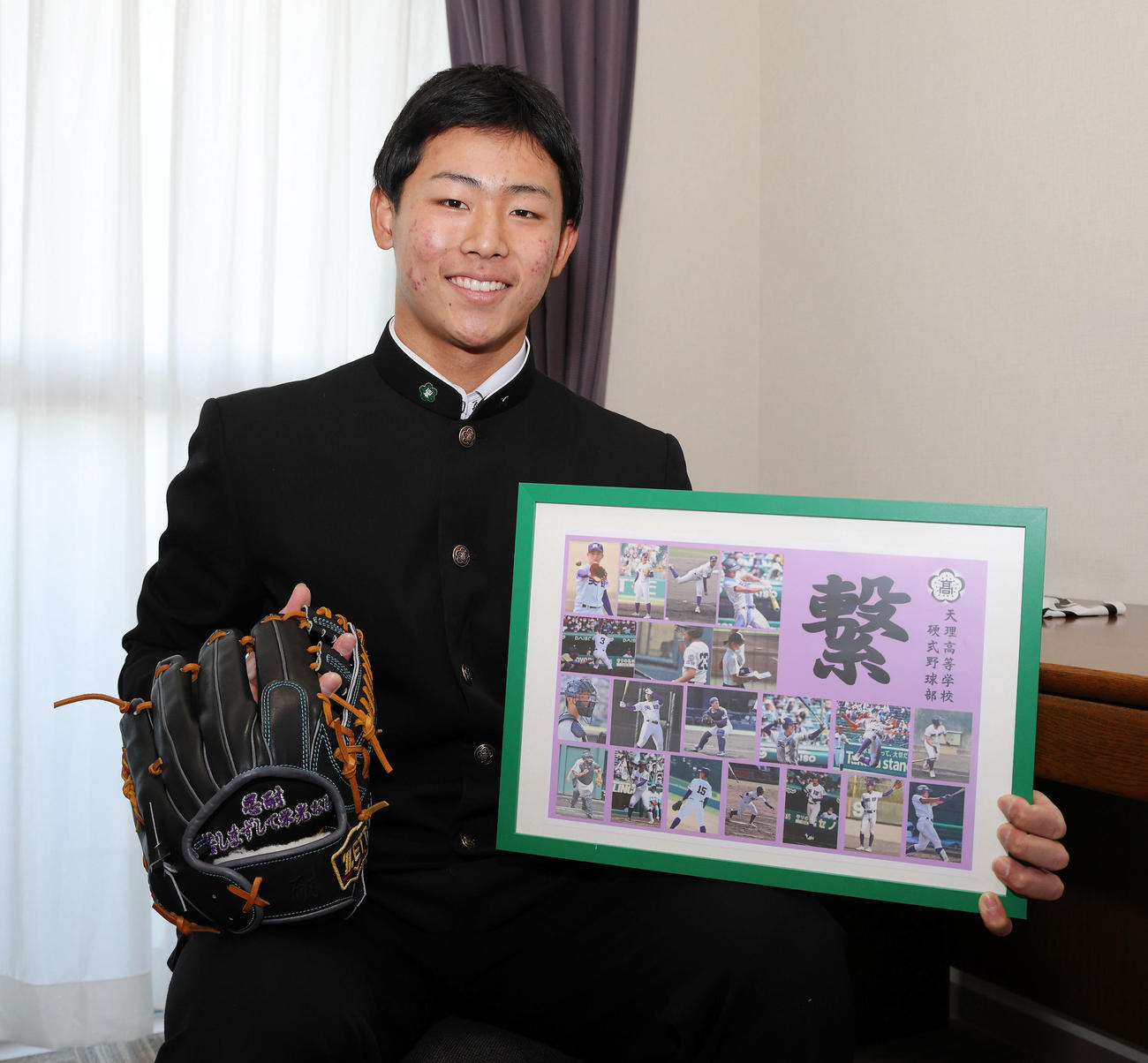 鳴尾浜球場内の虎風荘に入寮し天理高のメッセージボードとグラブを持つ戸井（球団提供）
