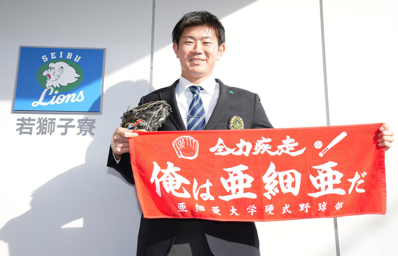 若獅子寮に入寮した西武ドラフト4位青山は亜大のタオルとグラブを手に笑顔（撮影・鈴木みどり）