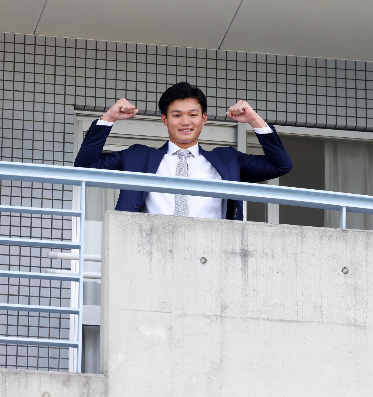 鳴尾浜球場の虎風荘に入寮し部屋のベランダでポーズを決める森下（球団提供）