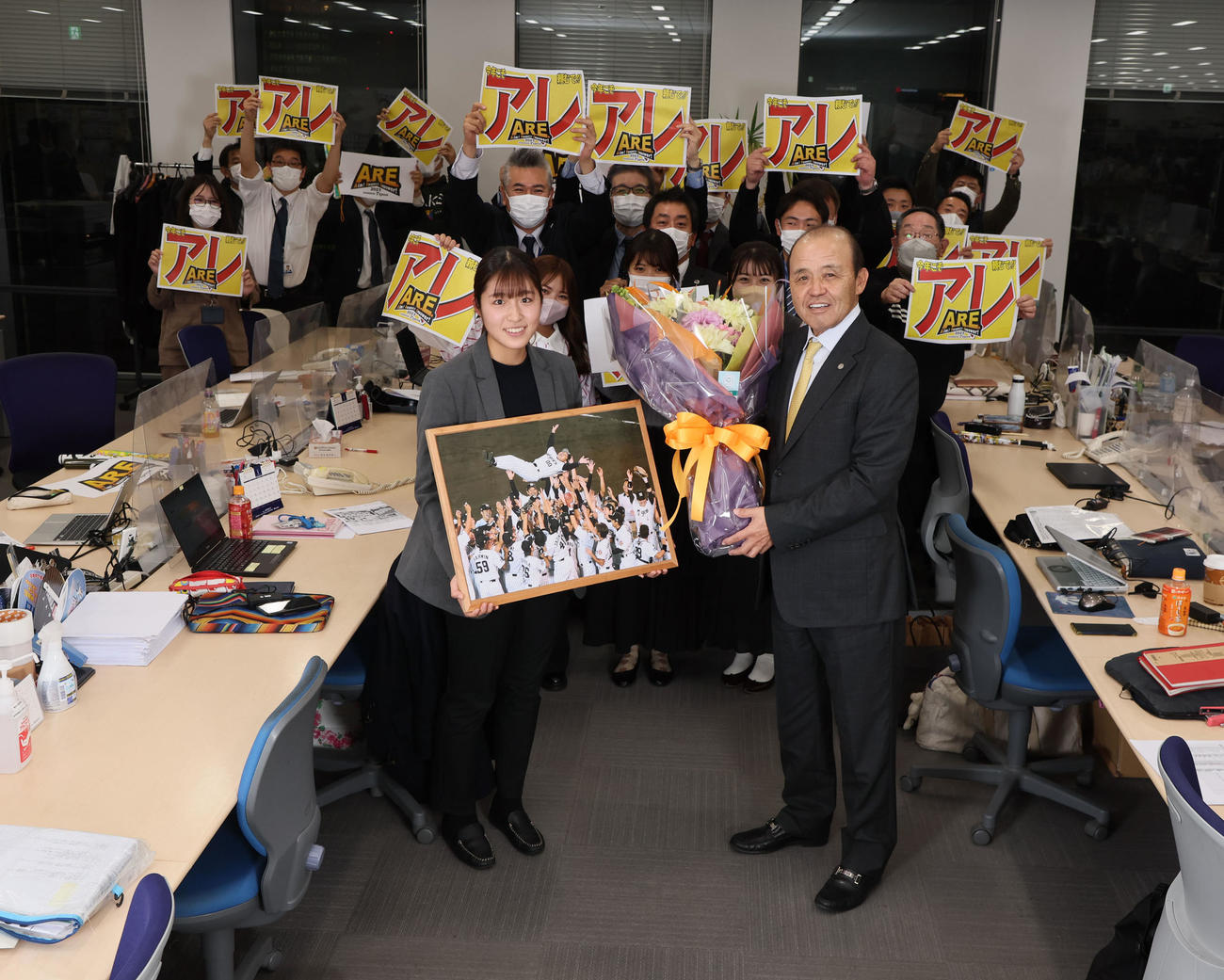 日刊スポーツ西日本本社を訪れた阪神岡田監督は花束を手に笑顔（撮影・加藤哉）