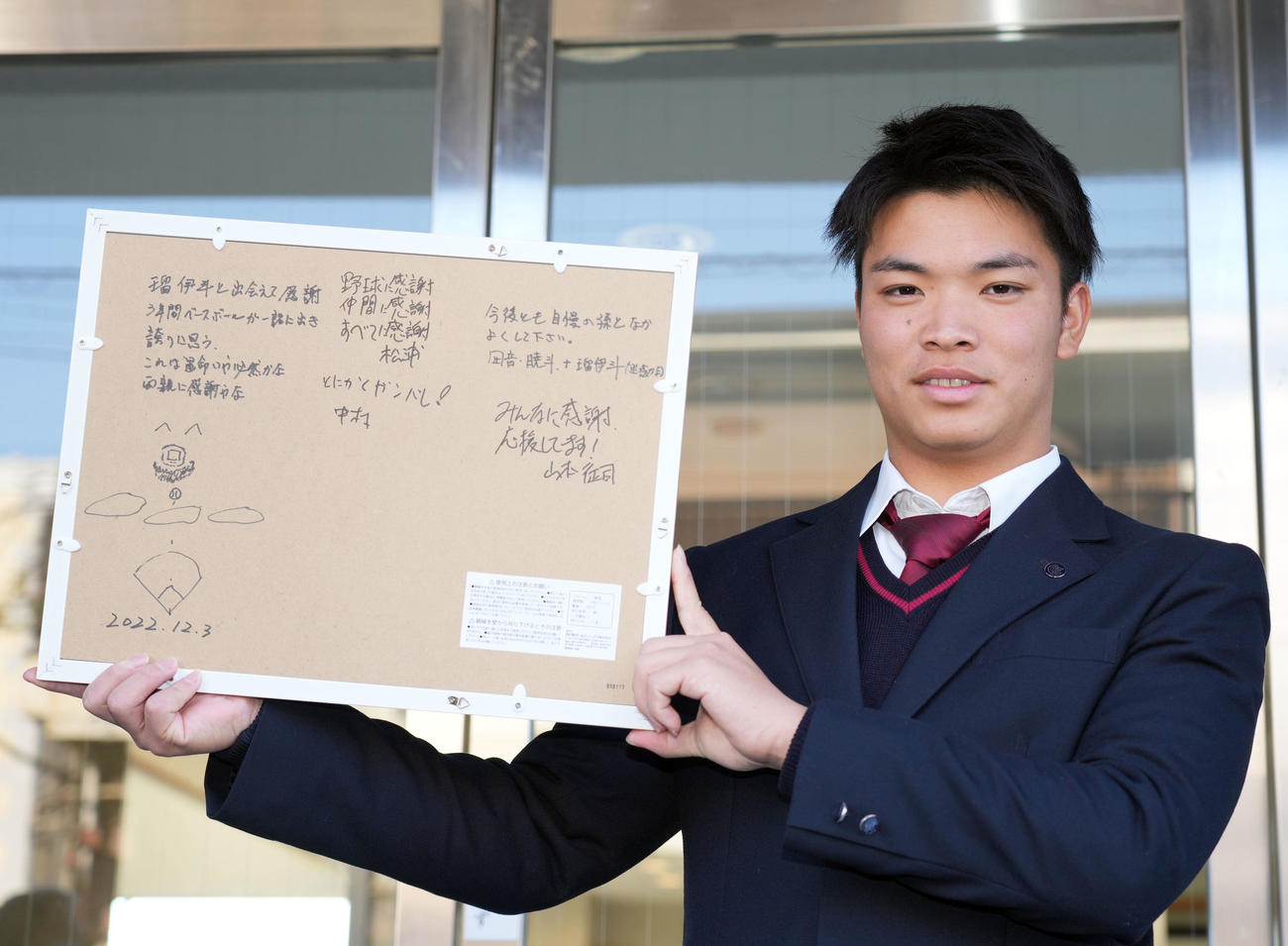 中学の恩師が書いてくれた色紙の裏に書かれた寄せ書きを見せるドラフト2位のヤクルト西村（撮影・狩俣裕三）