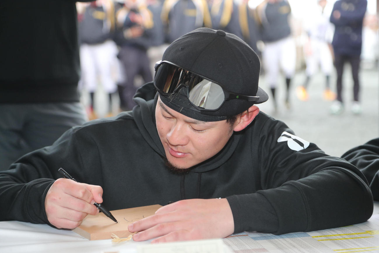 高良大社で絵馬に今年の目標を書き入れる牧原大成（撮影・梅根麻紀）