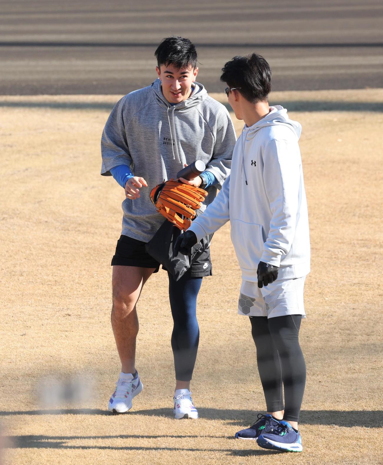 ファッションで右足だけ素肌を出している日本ハム山口。矢沢に指摘され苦笑いする（撮影・黒川智章）